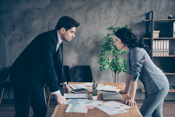 Photo of two partners seriously looking eyes competitive report standing near table workshop table