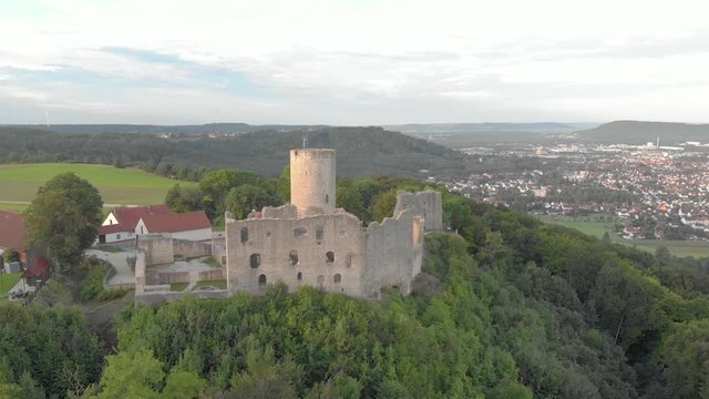Luftaufnahme der historischen Burgruine Wolfstein mit hohen Mauern, Burgfried umgeben von Wald bei leicht bew&ouml;lktem Morgenhimmel