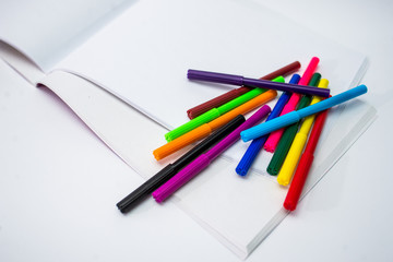  felt-tip pens and sketchbook on white