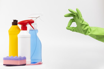 Close-up person with green glove and cleaning products