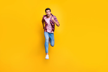 Full length body size photo of serious running man looking at camera moving towards it while isolated with yellow background © deagreez