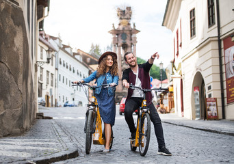 Obraz premium Young tourist couple travellers with electric scooters in small town.