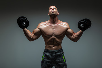 Brutal strong athletic men doing exercises with dumbbell .  Bodybuilding  and healty life concept. 
