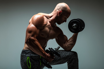 Brutal strong athletic men doing exercises with dumbbell .  Bodybuilding  and healty life concept. 