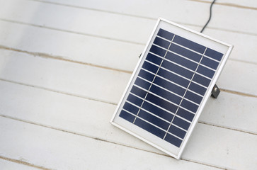 Solar cell panel on white wooden background.