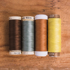 Line of reel of yarn on wooden background