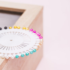 White pin box with colorful needles