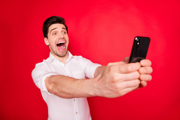 Photo of screaming laughing man taking selfie with pleasure while isolated with red background