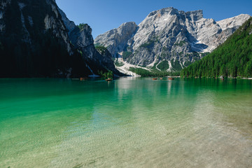 amazing view of braies lake with wooden boats on the water, surrounded by dolomites mountains. Trentino alto adige, Italy