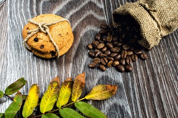 Autumn leaves, coffee grains and cookies on wooden background
