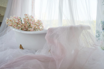 Lots of orchids and chiffon in the snow-white bath on the paws. Bathroom.