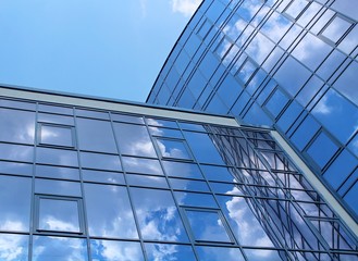 clouds reflected in the many mirrored facets of a modern office building