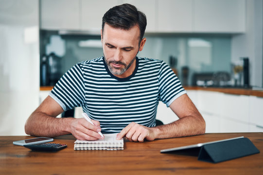 Handsome Man Sitting At Home And Managing Personal Finance