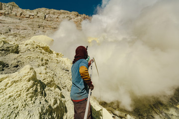 Sulfur miners extracting sulfur inside the crater of Kawah Ijen volcano in East Java, Indonesia