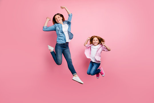 Full size photo of foxy little lady and her excited mom jumping high wear casual clothes isolated pink background