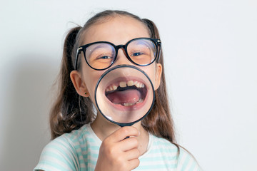 Little girl with a magnifying glass. The child looks like a happy monkey