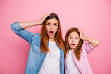 Portrait of impressed ginger haired girls with long hairstyle staring screaming wearing denim jeans shirt isolated over pink background