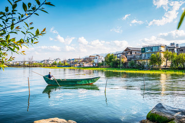Landscape of Erhai Lake, a man is rowing. Located in Dali, Yunnan, China.