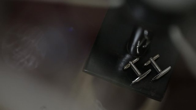 Men's golden cufflinks for a shirton in sunlights light sun glares Macro slider closeup