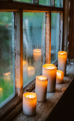 beautiful background with raindrops on the window and burning candles.
