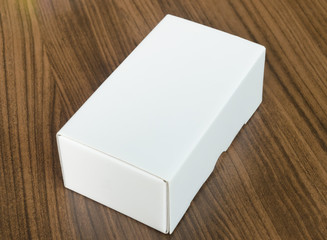 Mock up blank white box on brown wood background.