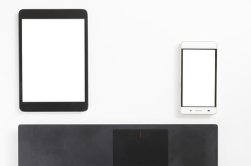 Office desk laptop smartphone and tablet on white. Top view with copy space.