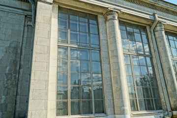 Fototapeta premium a row of large old windows on a gray stone wall of a building
