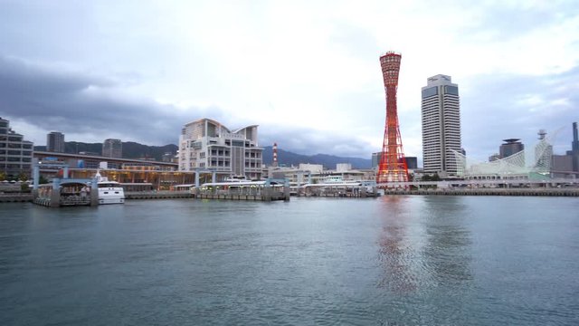 Panning right shot from the water of the city of Kobe in Japan showing the tower and skyscrapers