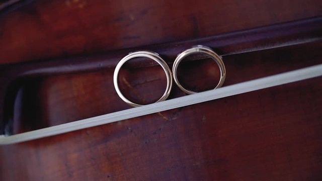Gold Wedding Rings macro closeup on bow for violin on a musical instrument diamon Jewellery