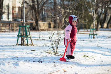 little child playing on the street in winter