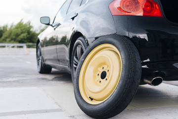 Car with spare tier propped on