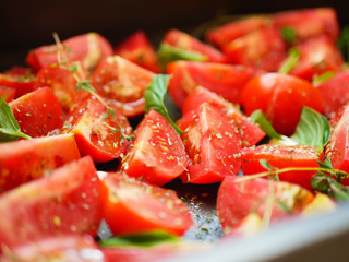 tomatoes with provencal herbs, basil, thyme and garlic. Vegetarian zucchini, tomatoes and bell pepper sauce, and ceramic tomatoes with herbs before baking. View from above. Close