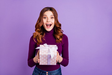 Portrait of cheerful lady holding hand package for anniversary screaming shouting isolated over purple background