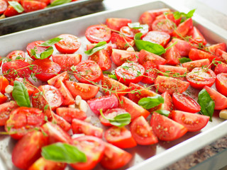 tomatoes with provencal herbs, basil, thyme and garlic. Vegetarian zucchini, tomatoes and bell pepper sauce, and ceramic tomatoes with herbs before baking. View from above. Close