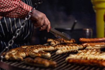 Chef cooking hotdogs at street food festival. Outdoor cooking service gastronomy and takeaway food concept