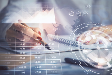 Double exposure of woman's hands making notes with forex graph hologram. Concept stock market analysis.