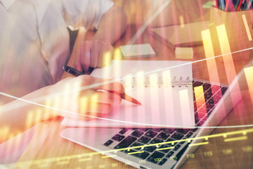 Financial charts displayed on woman's hand taking notes background. Concept of research. Double exposure