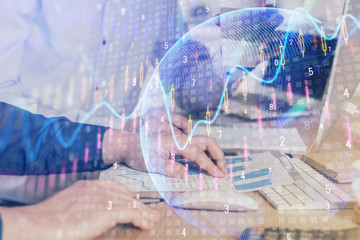 Stock graph with businessman typing on computer in office on background. Concept of analysis. Double exposure.