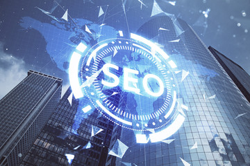 SEO hologram on city view with skyscrapers background double exposure. Search optimization concept.