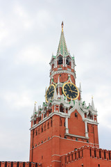 Fototapeta premium Moscow's Kremlin Spasskaya tower on Red Square in Russia. Kremlin building facade close up on moody cloudy day in Moscow city, capital of Russia