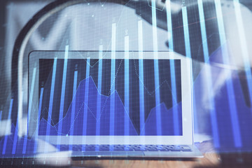 Stock market graph and table with computer background. Double exposure. Concept of financial analysis.