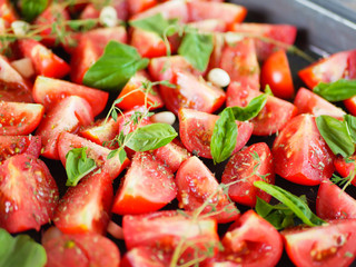 tomatoes with provencal herbs, basil, thyme and garlic. Vegetarian zucchini, tomatoes and bell pepper sauce, and ceramic tomatoes with herbs before baking. View from above. Close