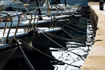 ropes from sailing boats secure them near dock in mediterranean bay in morning