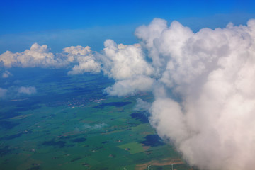 flight through the clouds and over green fields 