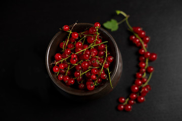 Red currants in a mug on a dark background. Strongly red delicious currants. A delicious background for use in the media.