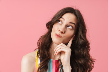 Fototapeta premium Thinking cute woman posing isolated over pink wall background.