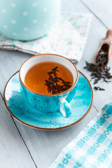 composition still life of a mug with hot leaf tea with berries and autumn leaves on a wooden surface