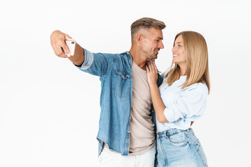 Portrait of romantic couple man and woman in denim clothing taking selfie photo together on smartphone