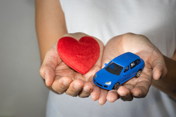 Toy car with heart in woman hand.