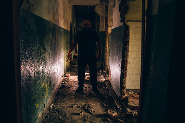 Obraz na płótnie Canvas Killer Silhouette with Knife in hand in dark corridor. Crime scene and trash horror maniac